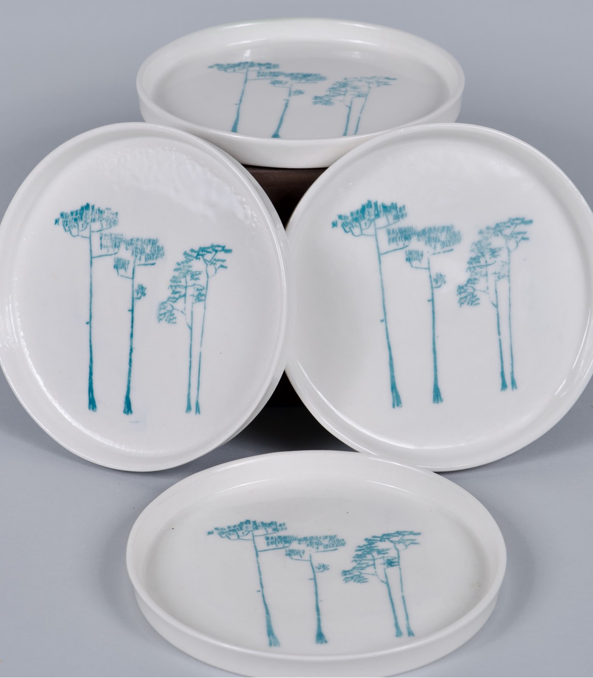 4 Petites assiettes "Pins", porcelaine et décor sérigraphié