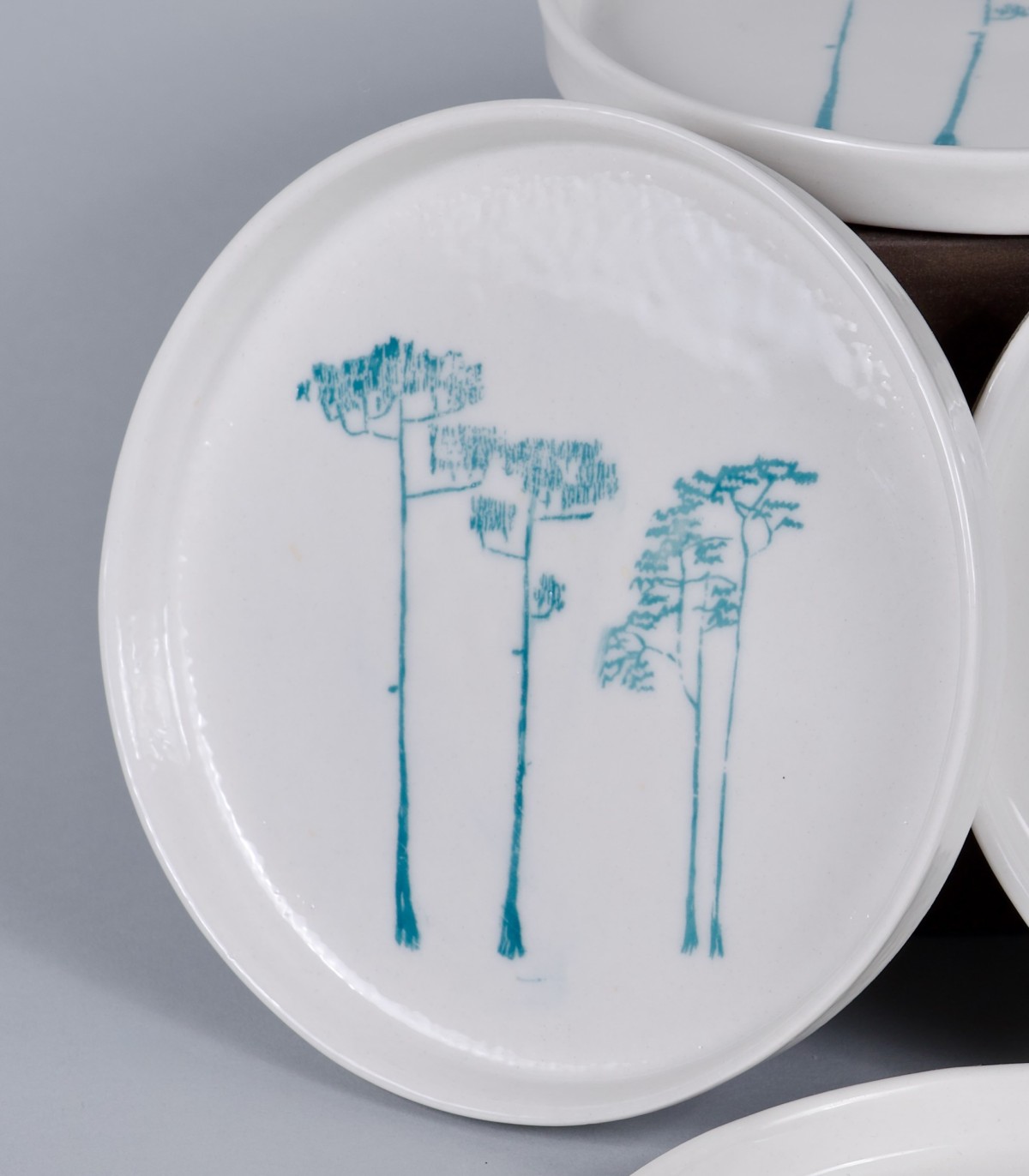 4 Petites assiettes "Pins", porcelaine et décor sérigraphié